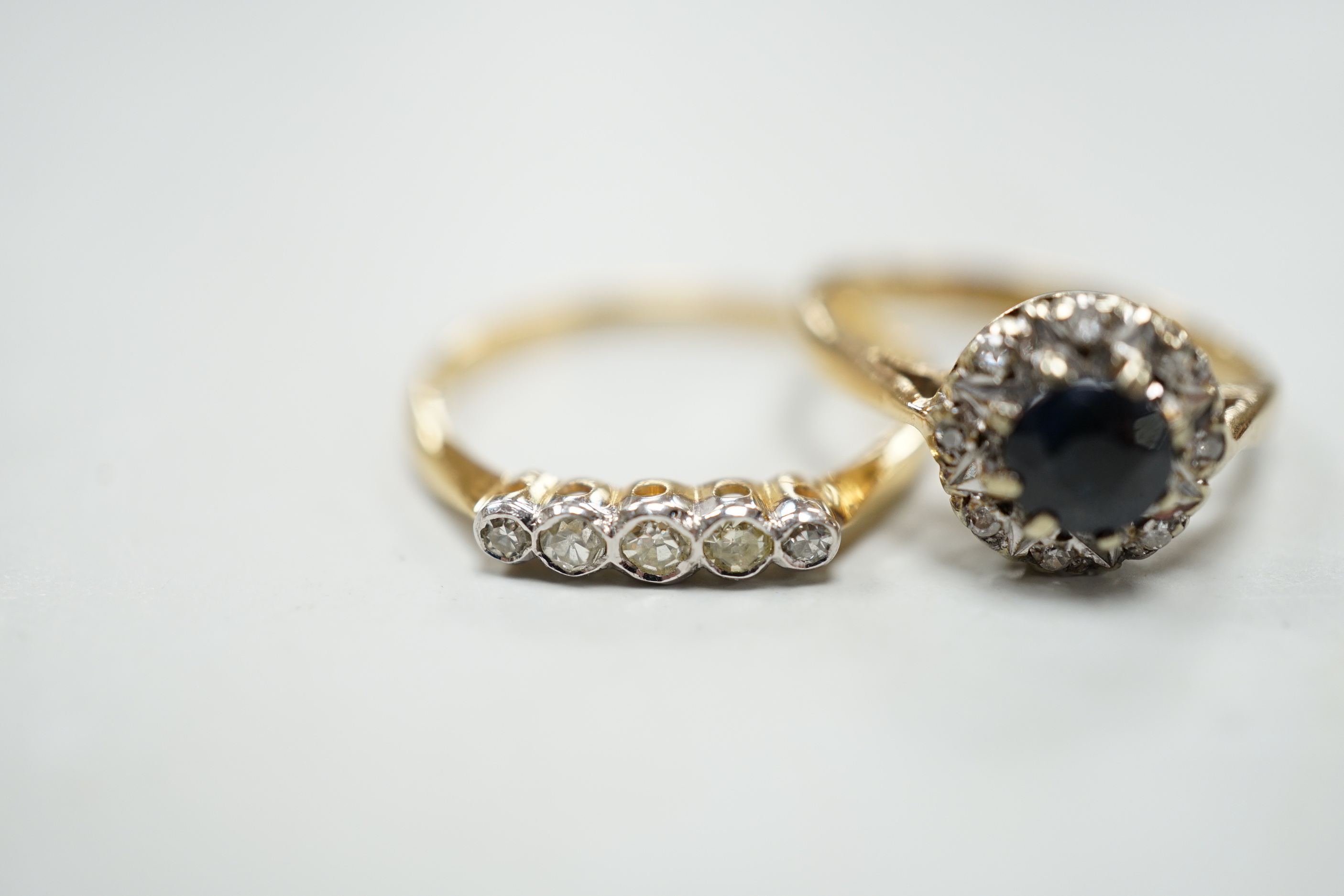 An 18ct and five stone diamond chip set half hoop ring and a modern 9ct gold, sapphire and diamond cluster ring.